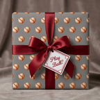 Vintage baseball wrapping paper by Wrapped Studios on a gift box with a red satin bow and Play Ball tag.