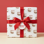 Square gift wrapped in Wrapped Studios baseball wrapping paper with a red satin bow.