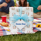Baseball wrapping paper for a game day gift, tied with a light blue ribbon and tag.