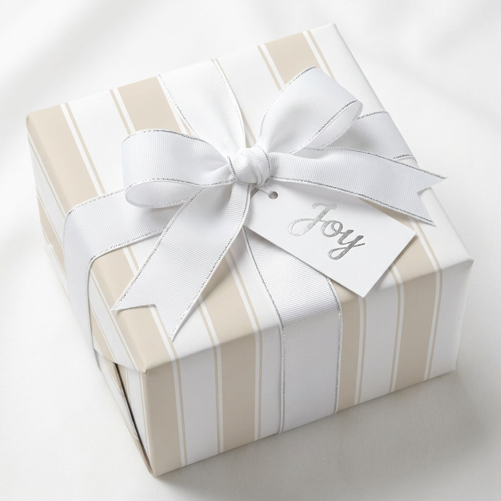 Beige striped wrapping paper with white bow and Joy tag, elegant luxury gift wrap by Wrapped Studios.