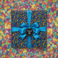 Square gift wrapped in colorful dot patterned paper with a blue satin ribbon and bow.
