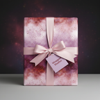 Elegant galaxy wrapping paper in shades of pink and gold, tied with a satin ribbon.