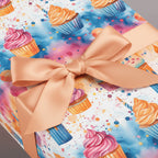 Pastel cupcake birthday wrapping paper with peach ribbon and watercolor confetti sprinkles.