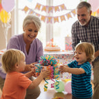 Toddlers exchanging a birthday gift wrapped in colorful paper with curly ribbon and a big bow.