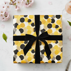 Modern polka dot wrapping paper in yellow, black, and white with a black velvet ribbon, perfect for a chic birthday or anniversary gift.