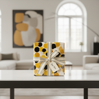 Modern polka dot wrapping paper in yellow, black, and white, tied with a cream ribbon and "For You" tag, on a white table.