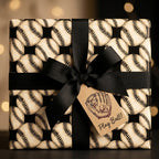 Vintage baseball wrapping paper with a black bow and "Play Ball" tag by Wrapped Studios.