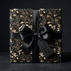Luxury dark floral wrapping paper with black satin bow and tag. Vintage botanical gift wrap by Wrapped Studios.