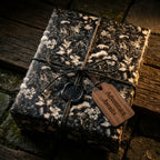 Luxury dark floral wrapping paper with vintage botanical design and twine bow, by Wrapped Studios.