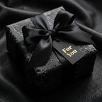 Black luxury gift wrap with satin ribbon and "For You" tag, presented by Wrapped Studios.