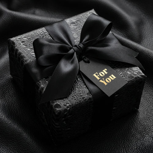 Black luxury gift wrap with satin ribbon and "For You" tag, presented by Wrapped Studios.