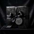 Black luxury gift wrap with an alligator skin pattern and satin ribbon, perfect for elegant birthday presents.