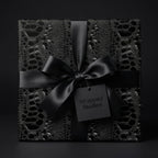 Elegant black gift box with luxury crocodile print wrapping paper and silk ribbon from Wrapped Studios.