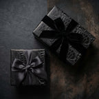 Luxury black gift wrap with a reptile print and elegant velvet ribbon bows from Wrapped Studios.