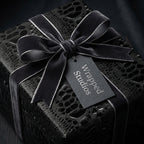 Wrapped Studios luxury gift wrap: Black crocodile-texture paper with a velvet ribbon.