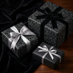 Elegant gifts wrapped in luxury black floral wrapping paper with velvet and satin ribbons.
