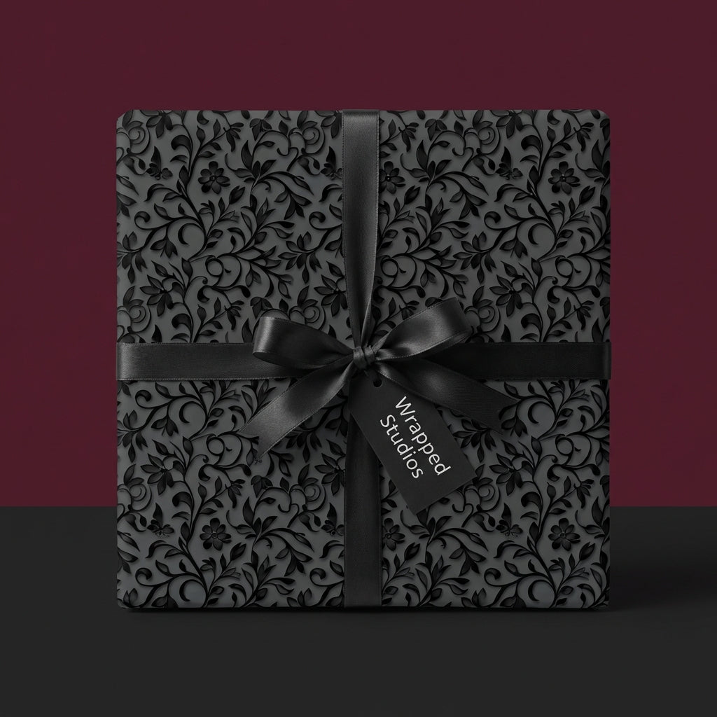 Elegant black floral wrapping paper with satin ribbon from Wrapped Studios.