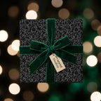 Wrapped Studios luxury gift wrap: Black floral wrapping paper with green velvet ribbon and bokeh lights.