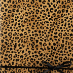 Tan gift box with black leopard print wrapping paper and a sleek black satin ribbon.