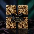Luxurious gift wrapped in leopard print wrapping paper with a black satin ribbon bow.