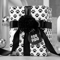Dog paw print wrapping paper by Wrapped Studios on a gift with a black satin bow and "For Fido" tag.