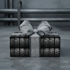 Unique gift wrapped in black tire tread pattern paper with a silver ribbon and bow.
