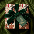 Luxury Black Mrs. Claus Christmas wrapping paper with a green velvet bow by Wrapped Studios.