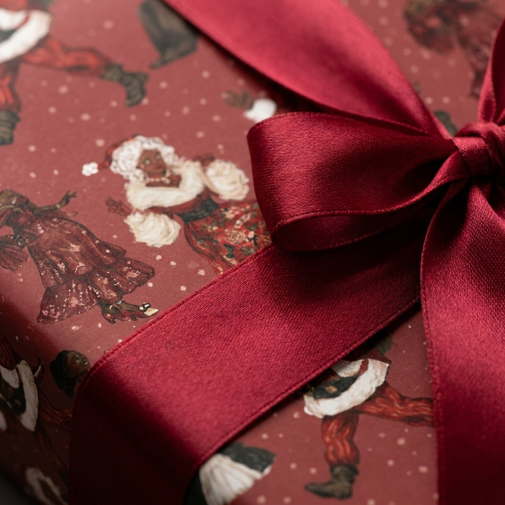 Black Santa luxury Christmas wrapping paper with a burgundy satin bow by Wrapped Studios.