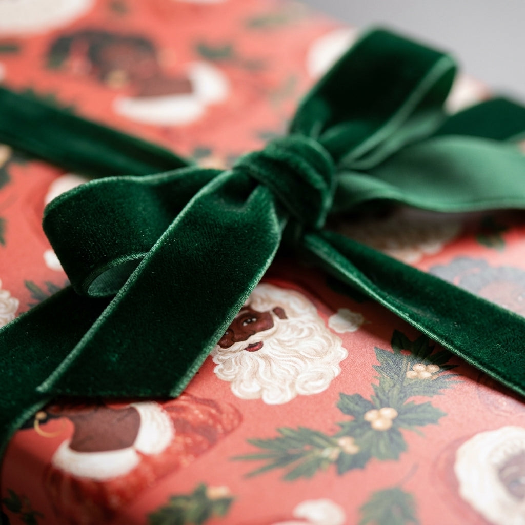 Black Santa Christmas wrapping paper with a luxury green velvet bow by Wrapped Studios.