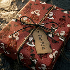 Vintage Black Santa Christmas wrapping paper by Wrapped Studios on a gift box with a rustic "For Him" tag.