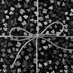 Elegant floral wrapping paper in grayscale, tied with a simple twine bow.