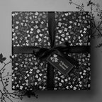 Elegant floral wrapping paper in monochrome with black ribbon and a "Special Gesture" tag.