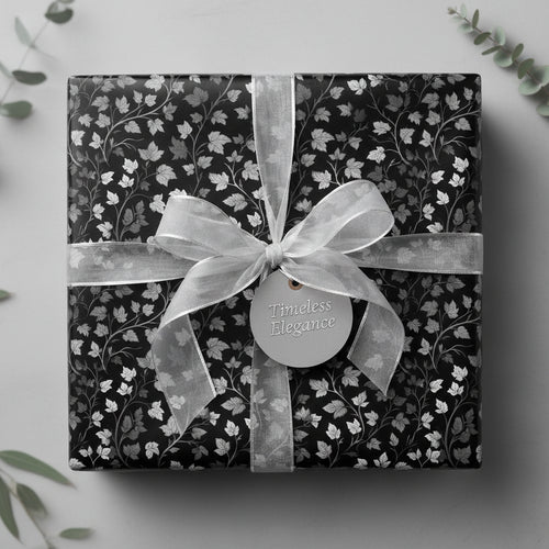 Elegant gift box in black floral wrapping paper with silver ribbon and "Timeless Elegance" tag.