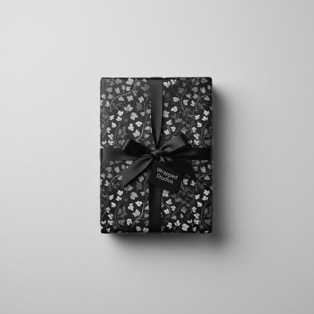 Elegant gift wrapped in floral wrapping paper with a black ribbon and a gift tag.