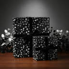 Elegant black and silver floral wrapping paper with velvet ribbon for luxury gift wrap.