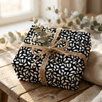 Minimalist black and white abstract wrapping paper on a gift box tied with rustic jute twine and dried eucalyptus.