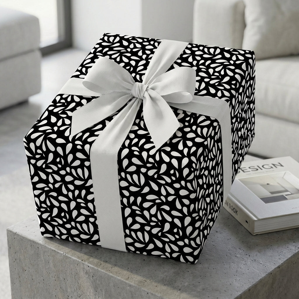 Elegant black and white wrapping paper featuring a modern abstract pattern, tied with a large white ribbon bow on a stylish gift box.