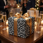 Elegant black and white wrapping paper with a large gold satin ribbon bow, ideal for luxury wedding, anniversary, or holiday gifts.