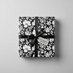 Elegant gift wrapped in black and white floral wrapping paper with black satin ribbon.