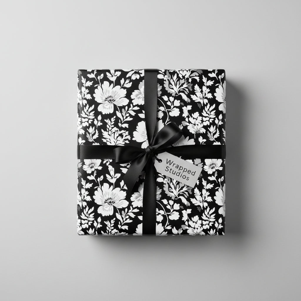Elegant gift wrapped in black and white floral wrapping paper with black satin ribbon.
