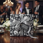 Elegant black and white floral wrapping paper with silver ribbon at formal event.