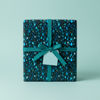 Teal ribbon on wrapped gift box with raindrop-patterned wrapping paper.