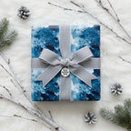 Elegant Christmas gift wrap with blue abstract pattern and silver ribbon on white faux fur.