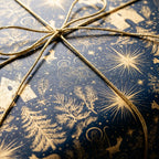 Navy and gold nativity wrapping paper with a gold twine bow, luxury Christmas gift wrap by Wrapped Studios.