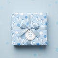 Square gift wrapped in blue baby shower wrapping paper with ribbon and "For a Little Star" tag.