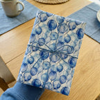 Gift wrapped in blue balloon pattern birthday wrapping paper with twine bow.