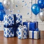 Blue watercolor balloon birthday wrapping paper on elegant gift boxes by Wrapped Studios.