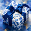 Luxury blue balloon birthday wrapping paper with a satin bow and gift tag by Wrapped Studios.