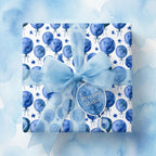 Blue watercolor balloon birthday wrapping paper with a sheer bow and gift tag by Wrapped Studios.