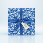 Square gift wrapped in blue camo wrapping paper with satin ribbon and tag.